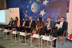 fot. Natalia Mykhailovska/NIW-CRSO 7 osób siedzących na scenie podczas konferencji - paneliści